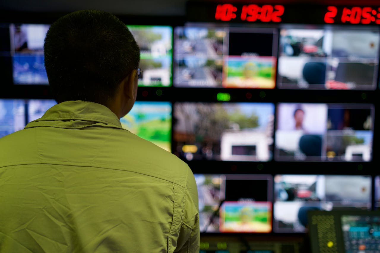 Crafting Captivating Headlines: Your awesome post title goes here Man in a control room overseeing multiple monitors displaying various scenes.